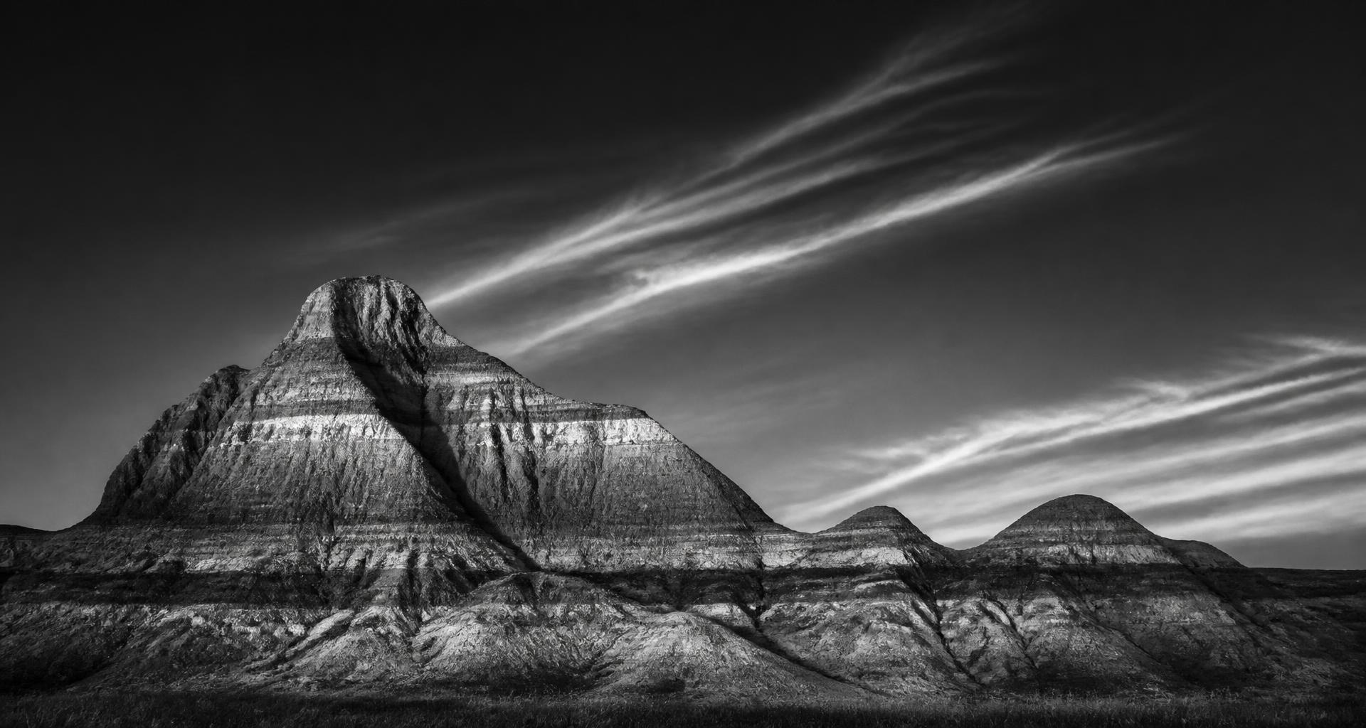 Striated badlands buttes of western North Dakota in black and white