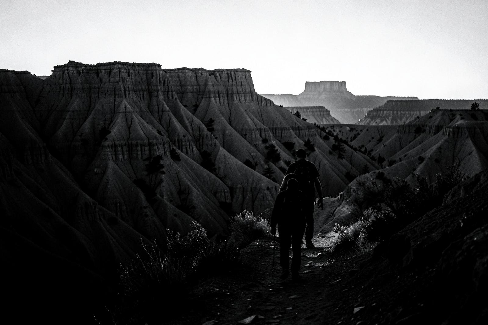 Two people hiking a badlands trail
